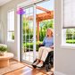 Senior woman in a power wheelchair rolls through an open sliding patio door automated by SmartSlydr, with a wall-mounted button beside the door
